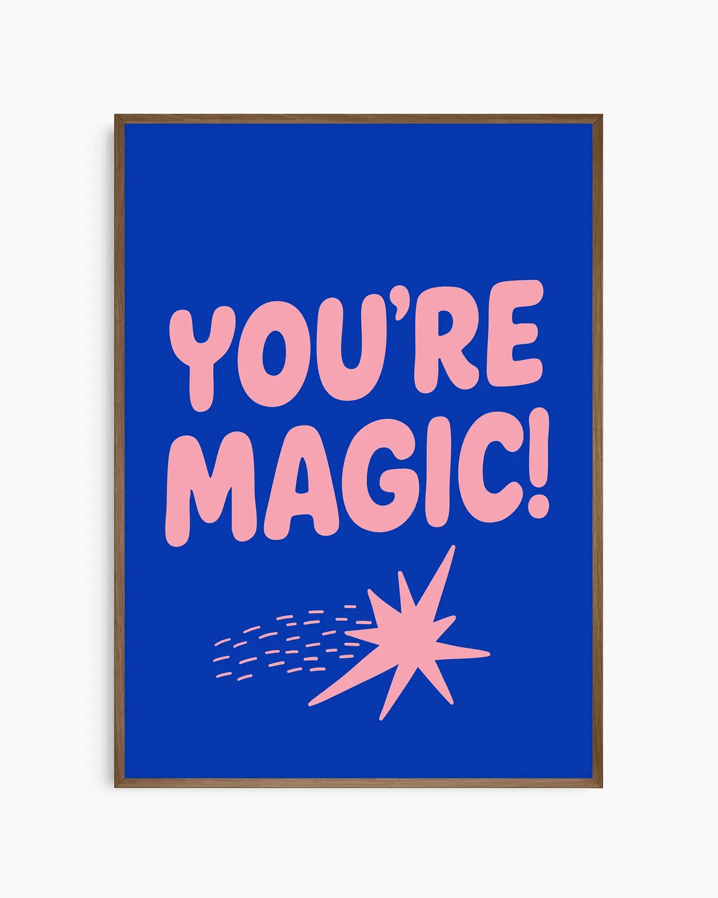 Blue nursery poster with pink text 'YOU'RE MAGIC!' and a shooting star framed in a dark oak frame.
