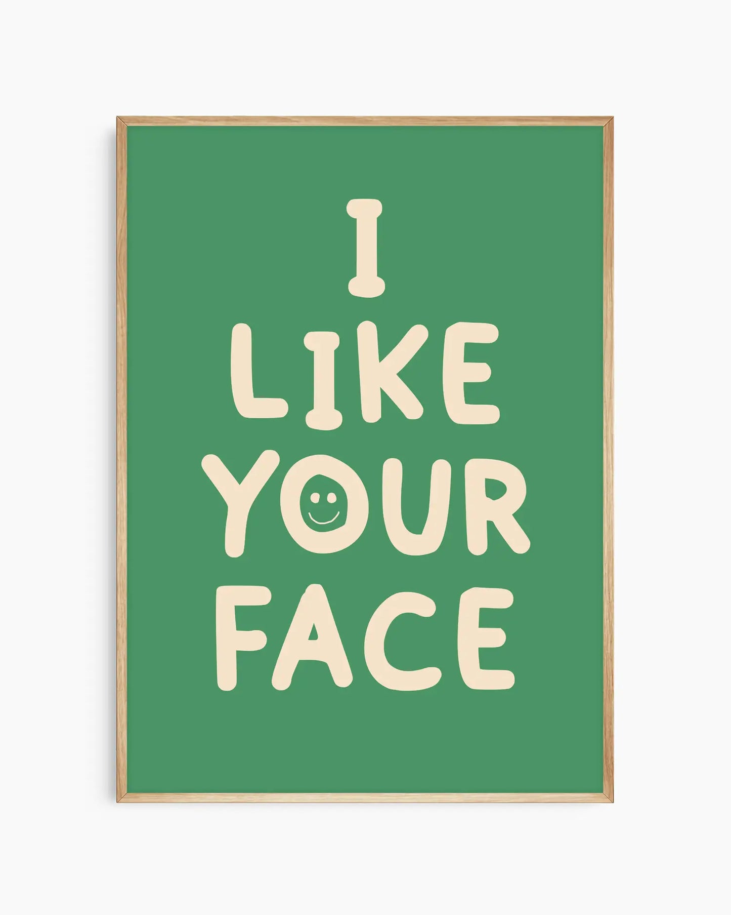 Green nursery poster with the text 'I like your face' written in beige, framed in an oak frame.