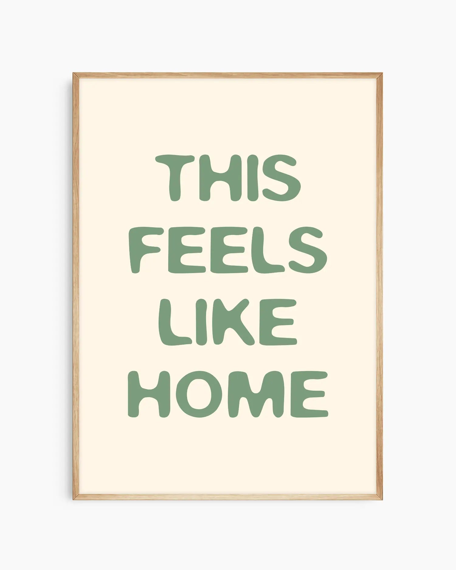 Nursery poster with the text 'This feels like home' written in green, inserted in an oak frame