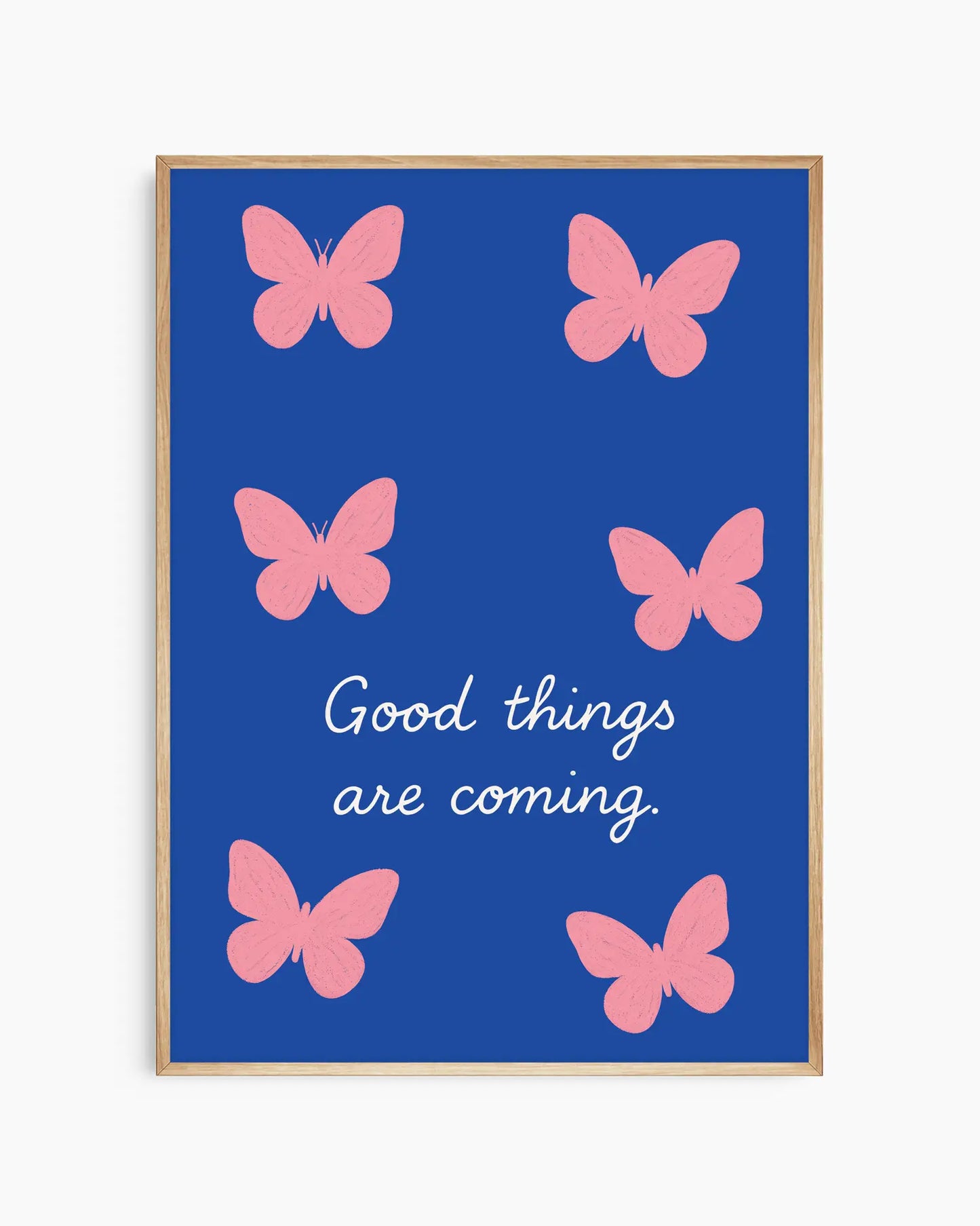 Framed artwork with pink butterflies and 'Good things are coming' text on a blue background