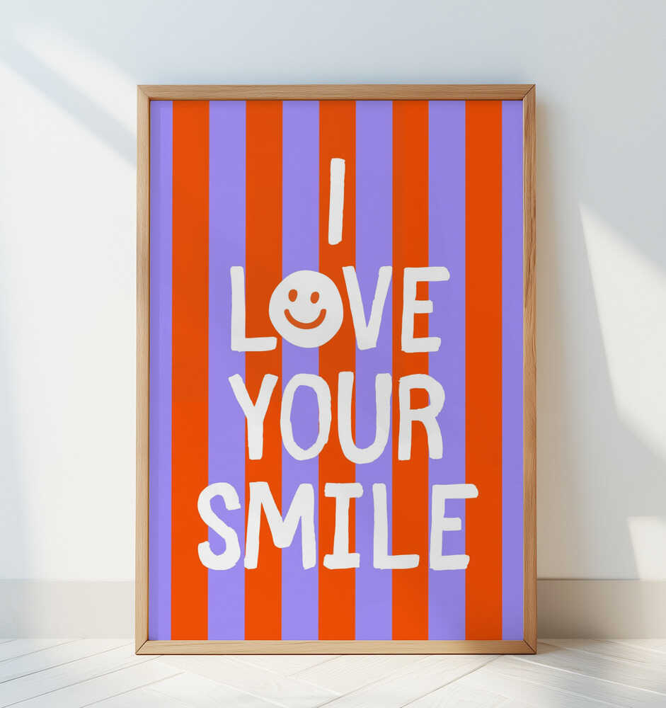 Framed poster with the text 'I love your smile' on a striped background, leaning against a white wall.