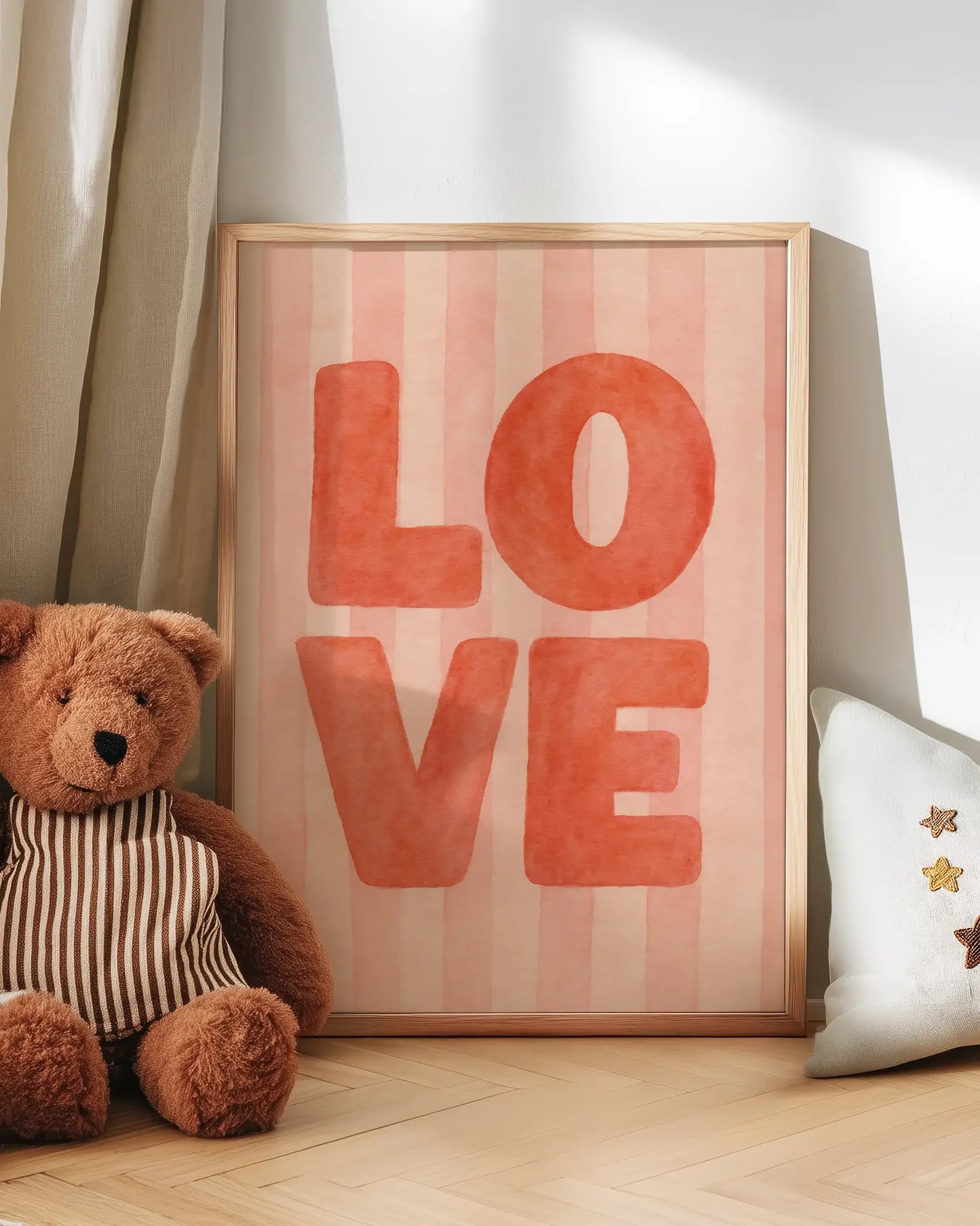 Teddy bear next to a framed poster with 'LOVE' on a wooden floor.