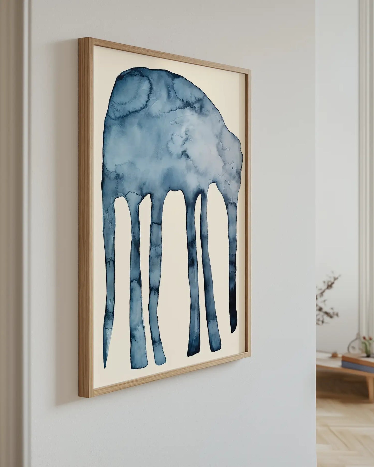 Framed artwork of a blue elephant on a white wall.