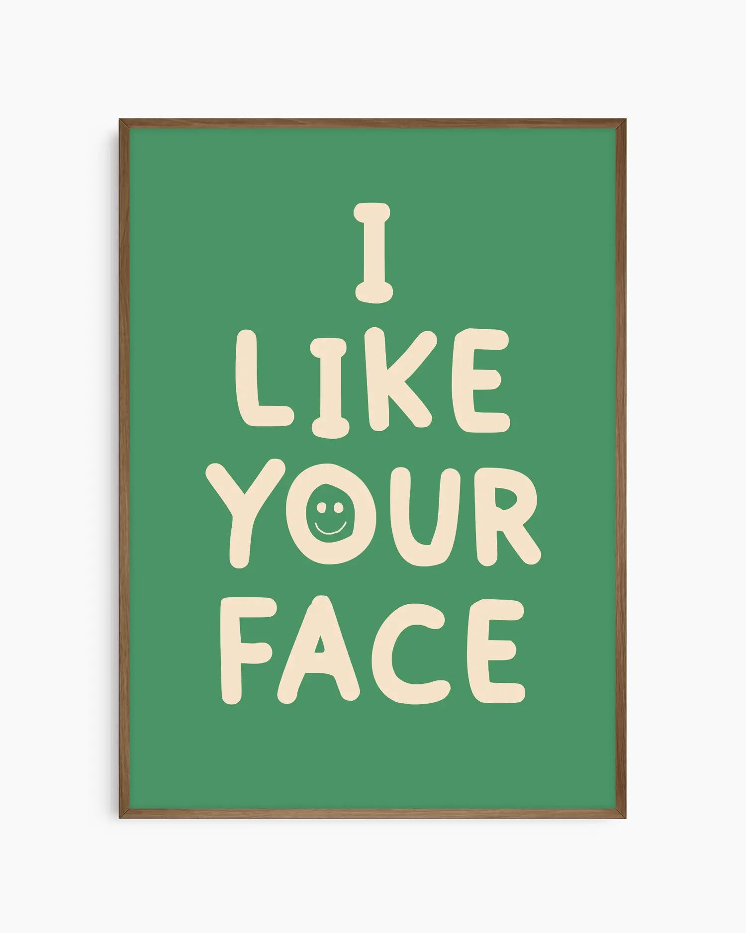 Green nursery poster with the text 'I like your face' written in beige, framed in a dark oak frame.