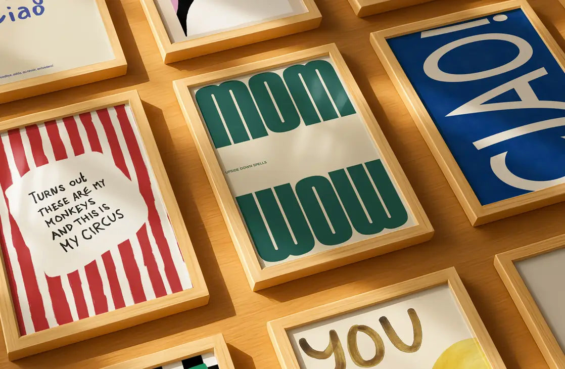 Collection of framed nursery posters with various text designs on a wooden surface