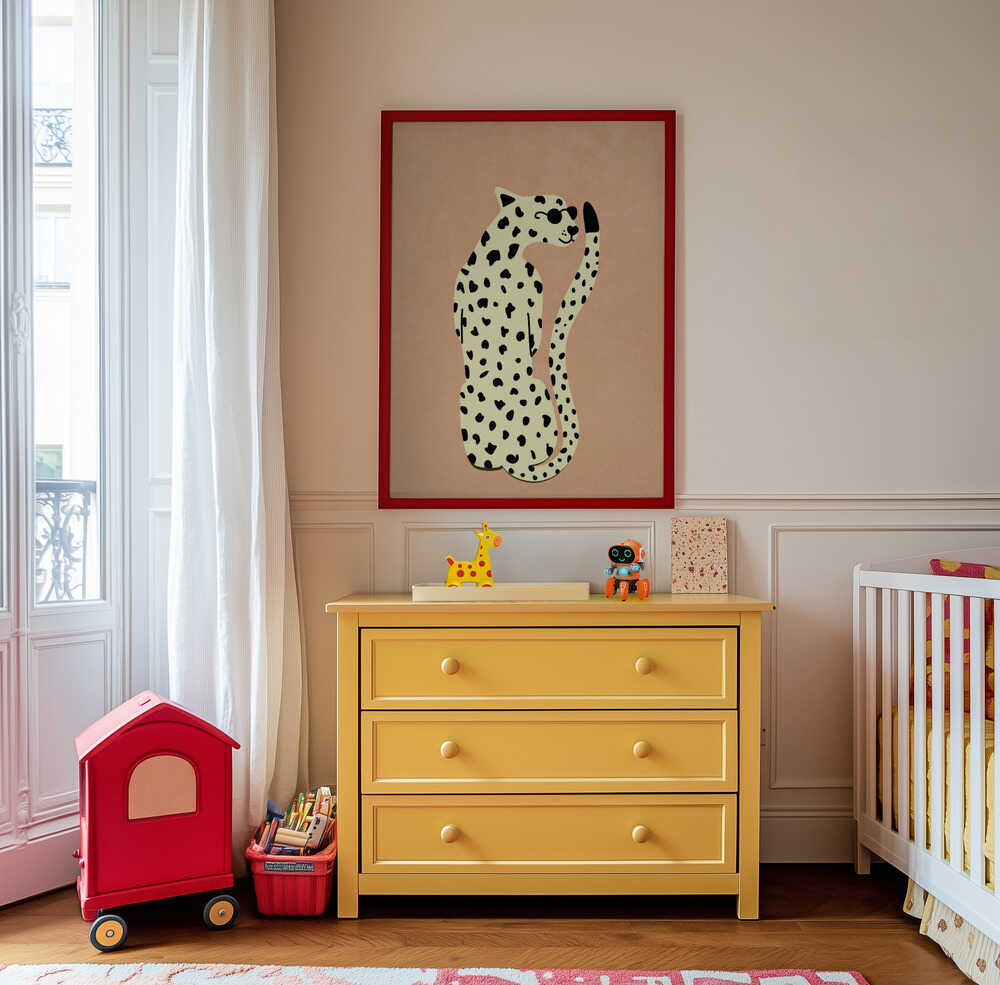 Minimalist leopard art print in a red frame hanging on the wall of a children’s room above a yellow dresser. The warm tones and playful design add a cheerful, modern touch to the space.