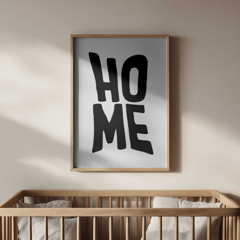 Framed nursery poster with the text 'HOME' written in black hanging in the kids room.